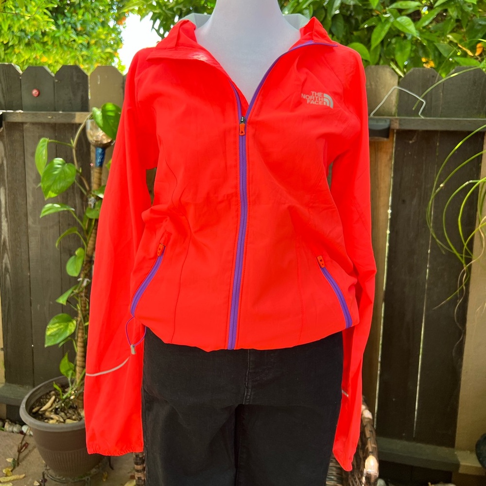 The North Face windbreaker in neon coral pink with zippered pockets